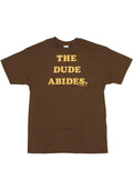 The Big Lebowski the Dude abides words graphic on a dark brown adult t-shirt.